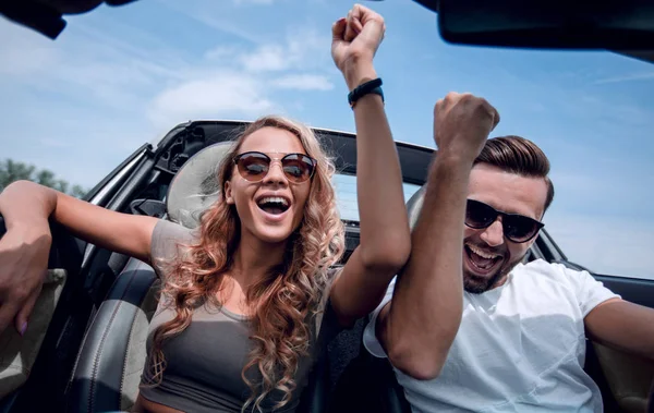 Close up. a happy couple travelling in a convertible . — стоковое фото