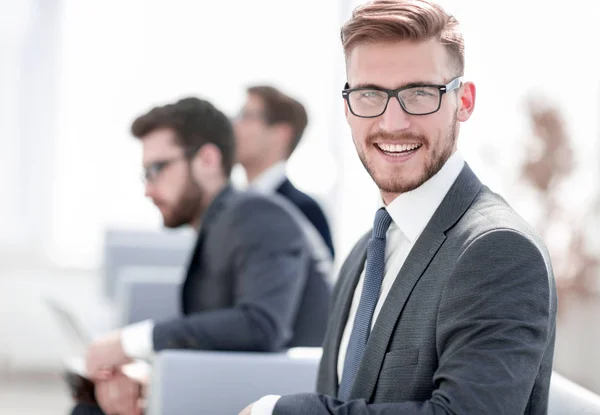 Sorridente empresário no fundo do escritório borrado — Fotografia de Stock