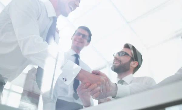 Onderaanzicht. handdruk medewerkers boven de balie — Stockfoto