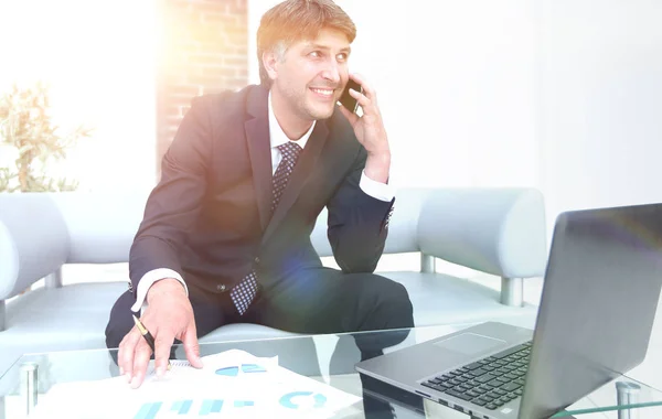 Uomo d'affari sicuro seduto alla scrivania dell'ufficio — Foto Stock