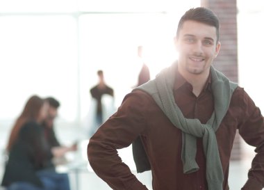 Kendine güvenen genç adam ofis arka planda.