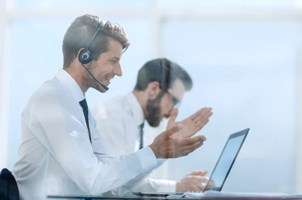 Büroangestellte mit eingeschaltetem Headset während einer Videokonferenz — Stockfoto