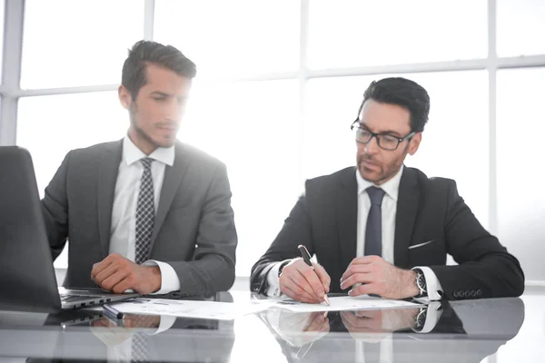 Two businessmen discuss financial documents — Stock Photo, Image