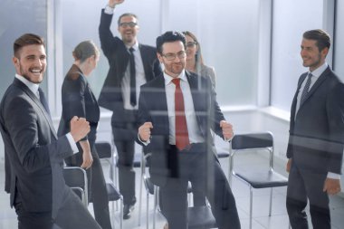 Muzaffer iş ekibi konferans odasında duruyor.