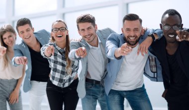 Bir grup insan kamerayı işaret ediyor ve gülümsüyor.