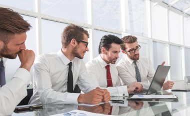 Konferans odasında bir masada oturan iş takım