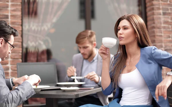 Üzletasszony egy csésze kávéval, ül egy asztalnál, egy hangulatos kávézó — Stock Fotó