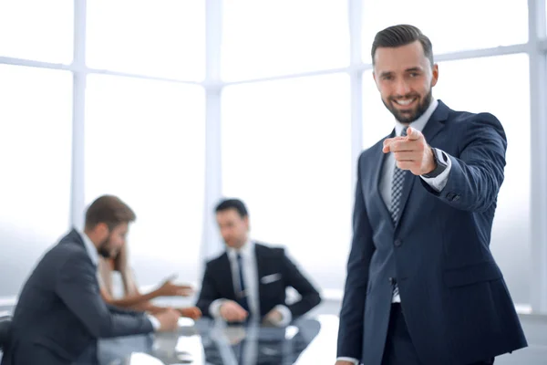 Hombre de negocios sonriente parado en la oficina y señalándote —  Fotos de Stock