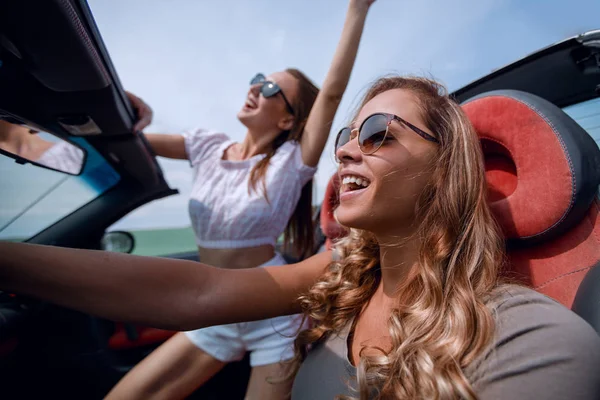Close up.happy jovens mulheres dirigindo um carro conversível — Fotografia de Stock