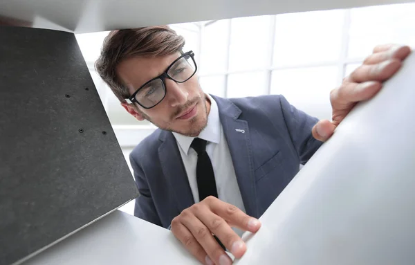 Young businessman selects a folder for documents — Stock Photo, Image