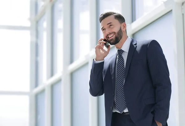 Leende affärsman talar på en mobiltelefon — Stockfoto