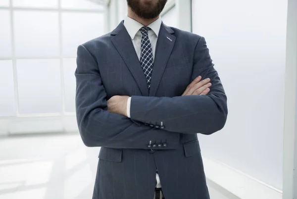 Close up. confident businessman standing in a bright office — стоковое фото