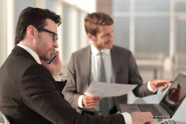 çalışanların yeni veriyi denetlemek için bir dizüstü bilgisayar kullanmak.