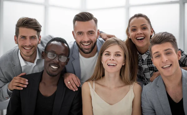 Grupo de jóvenes ejecutivos sonriendo a la cámara durante una reunión de trabajo — Foto de Stock