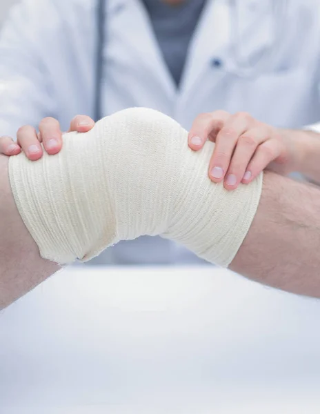 Traumatologist, het toepassen van een pleister op de knie — Stockfoto