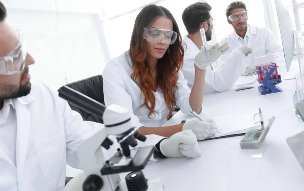 Group of young scientists discussing the results of a study — Stock Photo, Image