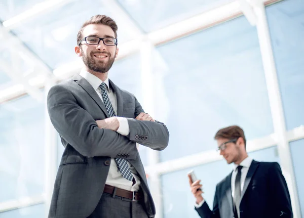 Hombre de negocios sonriente en el fondo de una oficina moderna — Foto de Stock