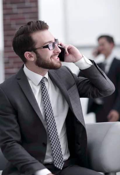 Charmig affärsman talar i telefon i en modern byggnad — Stockfoto