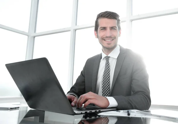 Leende affärsman sitter vid sitt skrivbord — Stockfoto