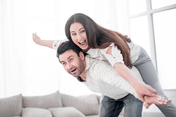 Pareja feliz descansando en una amplia sala de estar . — Foto de Stock