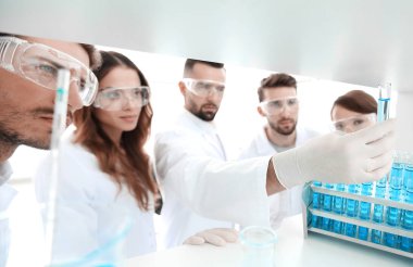 arka plan görüntüsü sıvı cam tüp içinde eğitim microbiologists oluşan bir gruptur.