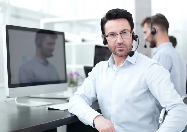Selbstbewusster Call-Center-Manager sitzt vor Computerbildschirm — Stockfoto