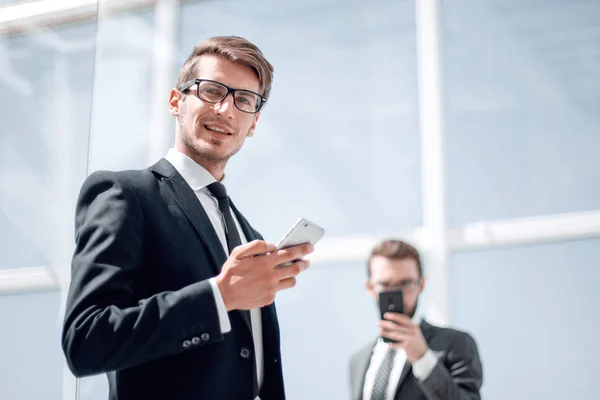 Moderna affärsman med en smartphone på bakgrunden office — Stockfoto