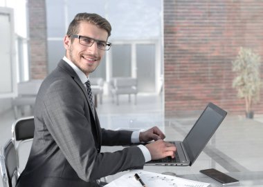 işadamı finansal verilerle çalışmak için bir dizüstü bilgisayar kullanarak