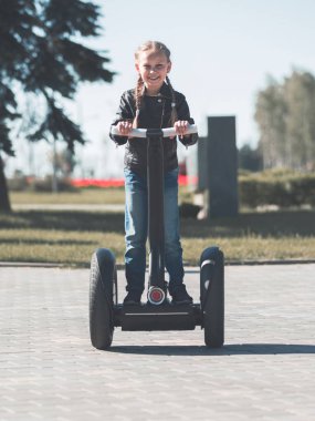 küçük bir kız parkta bir elektrikli mini hoverboard tesisi portresi.