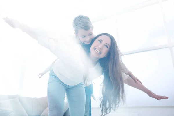 Mãe brinca com seu filho em uma espaçosa sala de estar — Fotografia de Stock