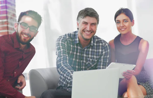 Groupe de jeunes collègues utilisant un ordinateur portable au bureau — Photo