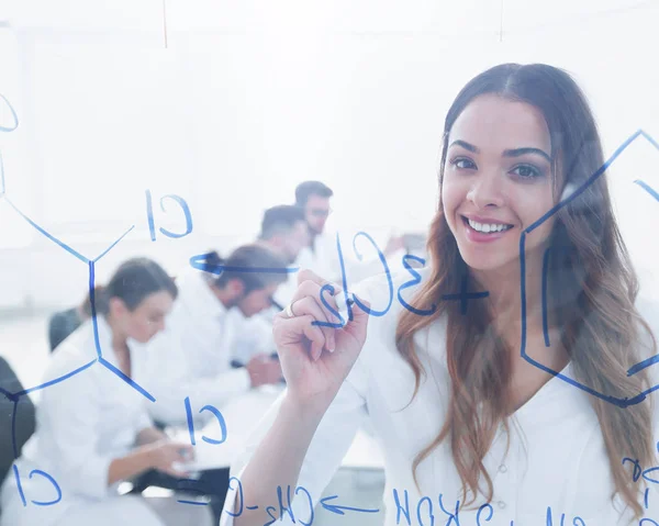 Smiling female assistant makes an entry on the Board. — Stock Photo, Image