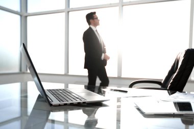 Ayakta ve toplantı odasına pencereden dışarı bakarak işadamı