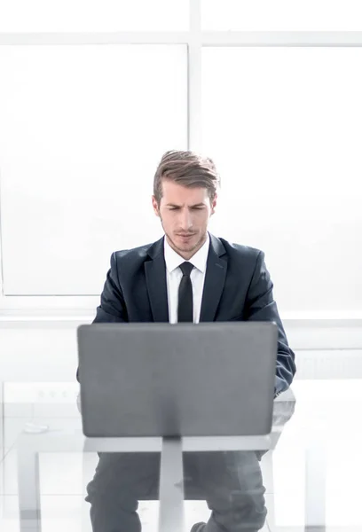 Självsäker affärsman sitter vid ett bord i ett rymligt kontor — Stockfoto