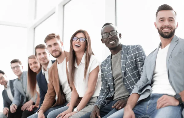 Jóvenes sentados en la pared esperando su turno en la entrevista — Foto de Stock