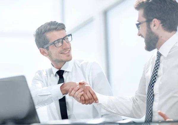 Handshake affärskollegor sitter vid sina skrivbord — Stockfoto