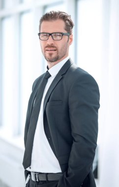 Kapat. Kendine güvenen iş adamı ofis penceresinin yanında duruyor.