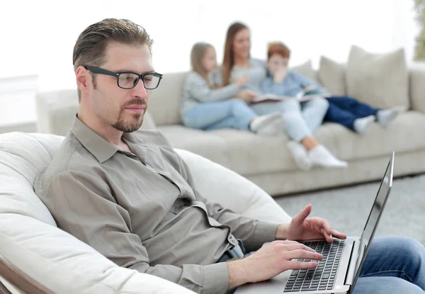 Succesvolle man met een laptop in zijn woonkamer — Stockfoto