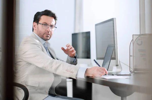 Imagem de um homem de negócios sentado em sua mesa . — Fotografia de Stock