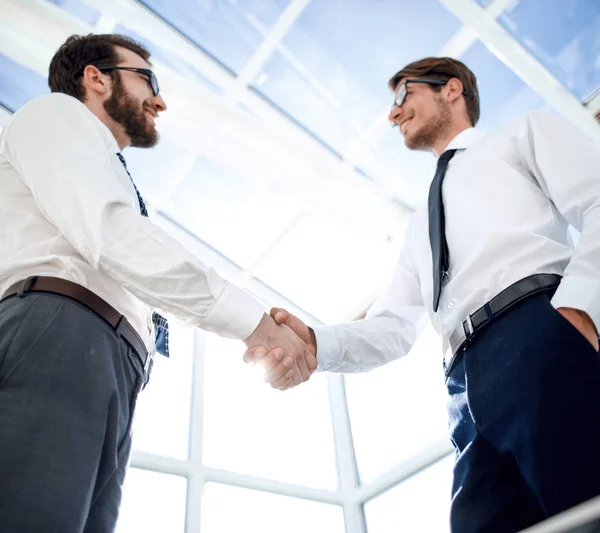 Inferior view.handshake gente de negocios de pie en la oficina —  Fotos de Stock