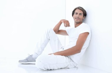 Beyaz bir duvar oturan endişeli adam