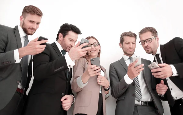 Business team tittar på skärmarna på sina smartphones — Stockfoto
