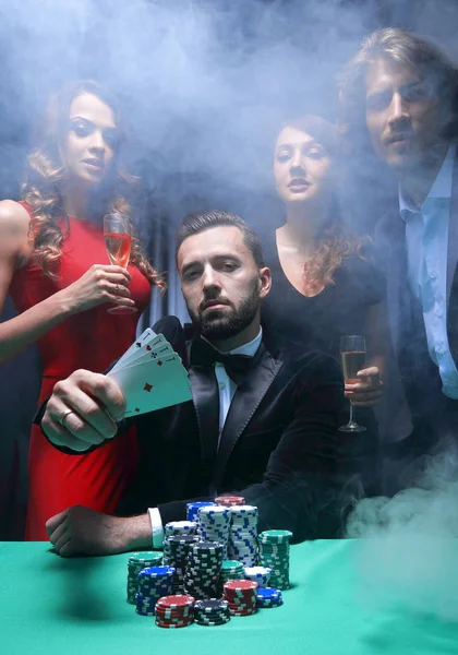 A happy company celebrates a victory in poker with champagne. — Stock Photo, Image