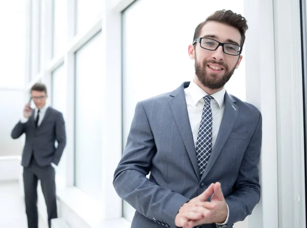 Задумчивый бизнесмен, стоящий в коридоре офиса — стоковое фото