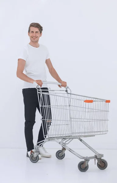 Giovane uomo spinge un carrello della spesa vuoto — Foto Stock