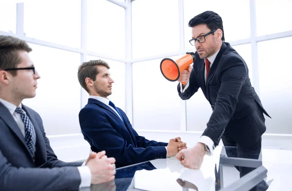 Strikt affärsman med en megafon på ett möte med anställda. — Stockfoto