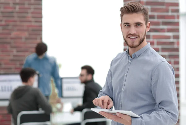 Hombre de negocios guapo usando una tableta en la oficina . — Foto de Stock