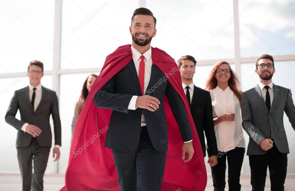 businessman is a superhero, stepping ahead of his business team