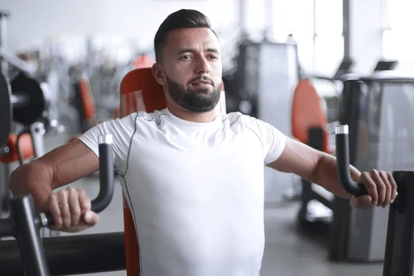 Joven hace entrenamiento con pesas en el gimnasio —  Fotos de Stock