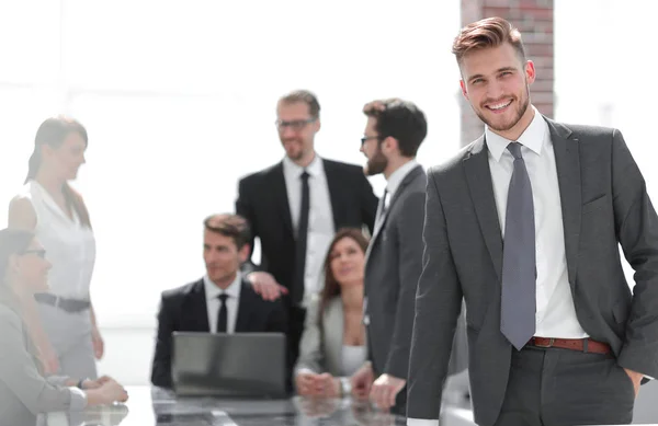 Uśmiechający się biznesmen stojący w pobliżu pulpitu — Zdjęcie stockowe